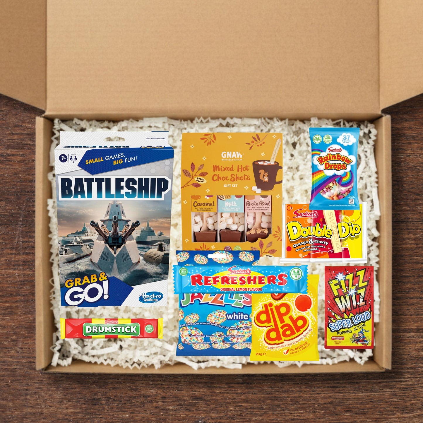 Gift box containing a battleships board game, GNAW mixed hot chocolate shots, and a selection of sweets