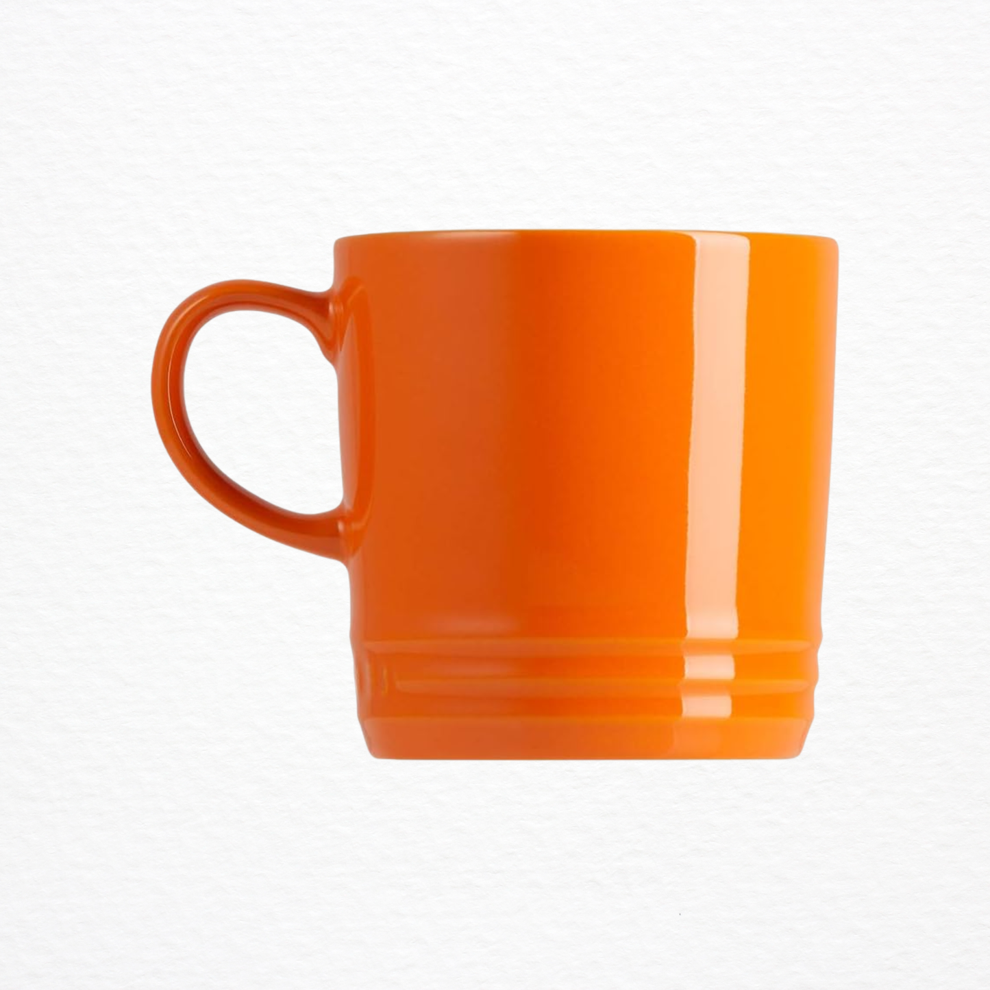An orange Le Creuset Stoneware Coffee Mug