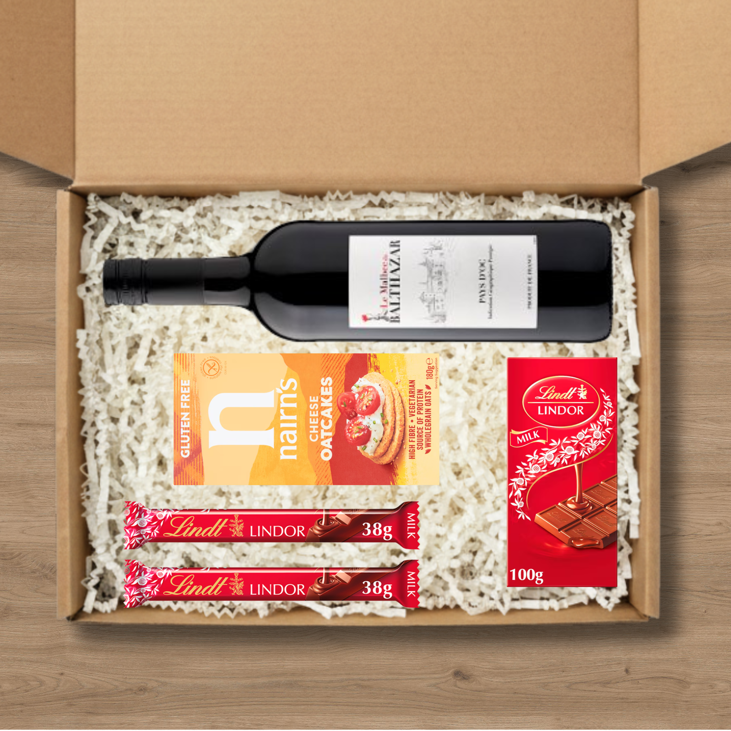 Gift box with a bottle of wine, cookies, and Lindt lindor chocolate bars