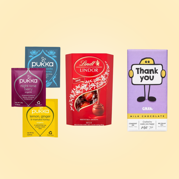 A selection of items on a pale yellow background. The items consist of: A range of Pukka teas, a box of Lindt Lindor milk chocolate truffles, and a GNAW chocolate bar with the words "Thank you" on the wrapper.