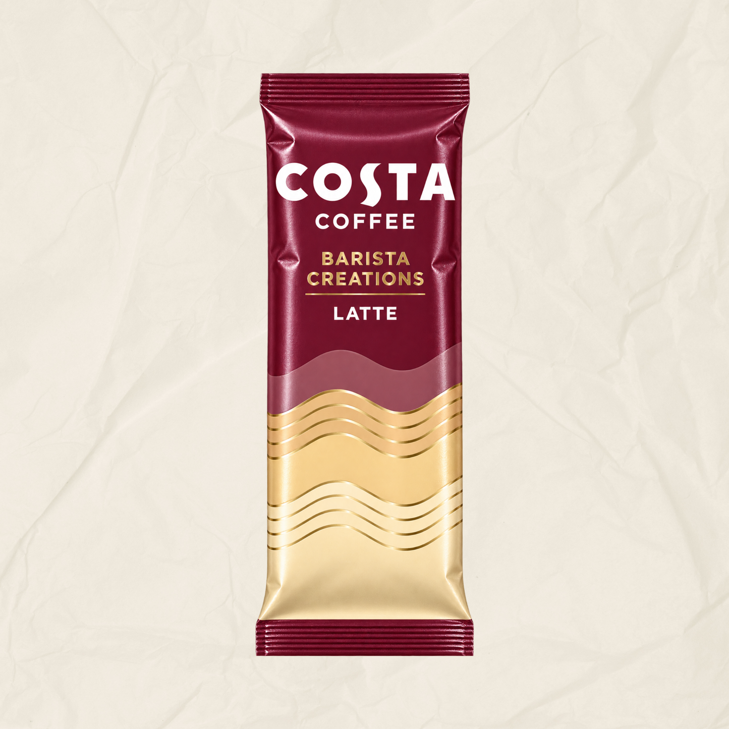 A single Costa Coffee Barista Creations Latte sachet standing upright on a textured off-white background. The packaging is deep burgundy with white and gold lettering and a gold wave pattern near the bottom.