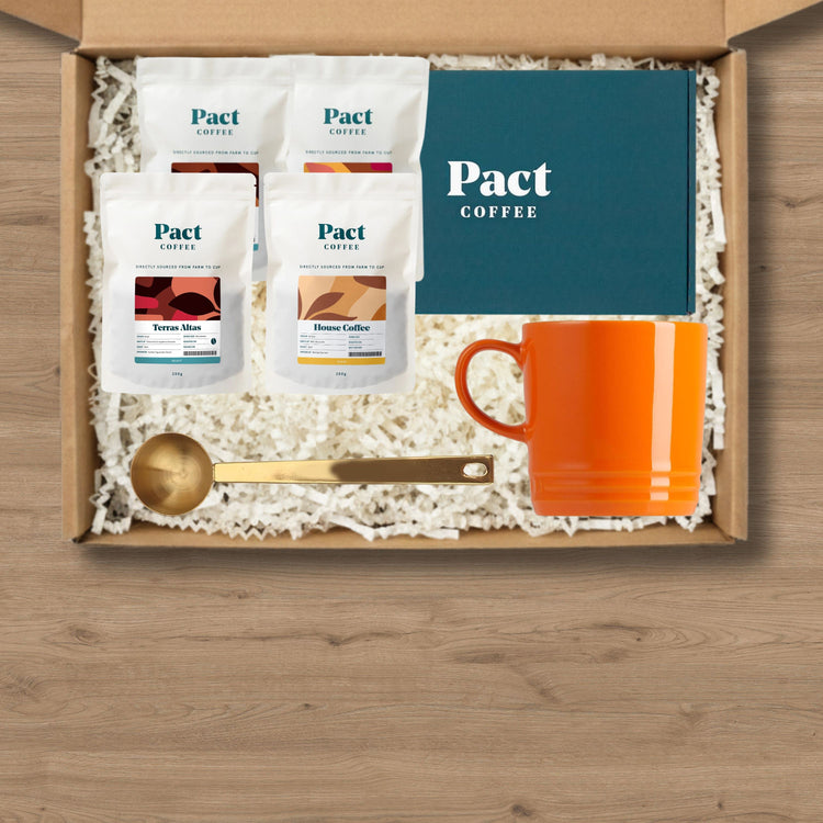 A gift box containing pact coffee, a mug and a coffee scoop.