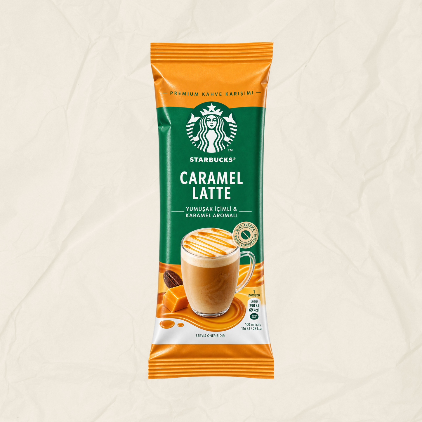 A single packet of Starbucks Caramel Latte instant coffee on a textured beige background. The packaging features a green and orange design with a photo of a caramel latte in a glass mug.