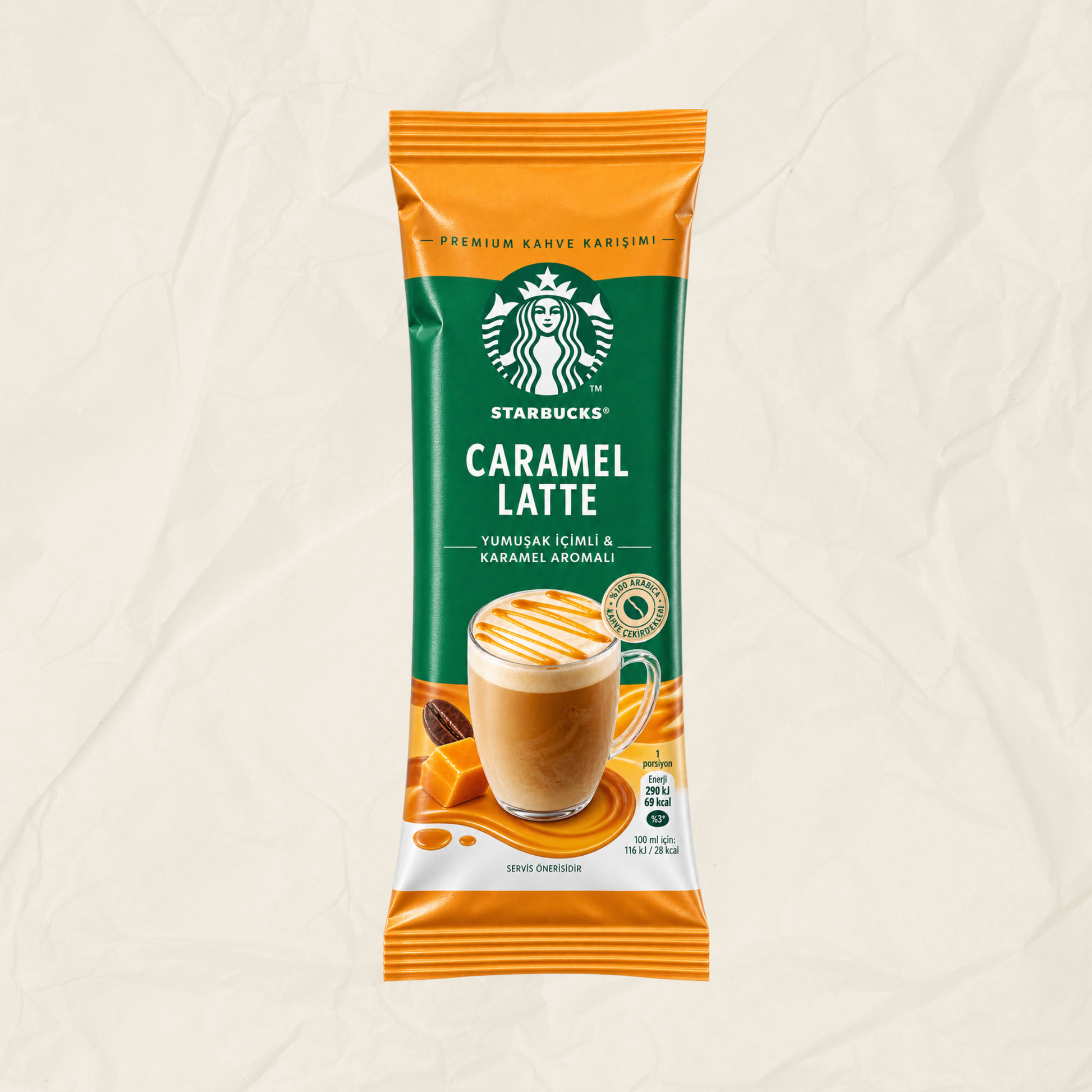 A single packet of Starbucks Caramel Latte instant coffee on a textured beige background. The packaging features a green and orange design with a photo of a caramel latte in a glass mug.