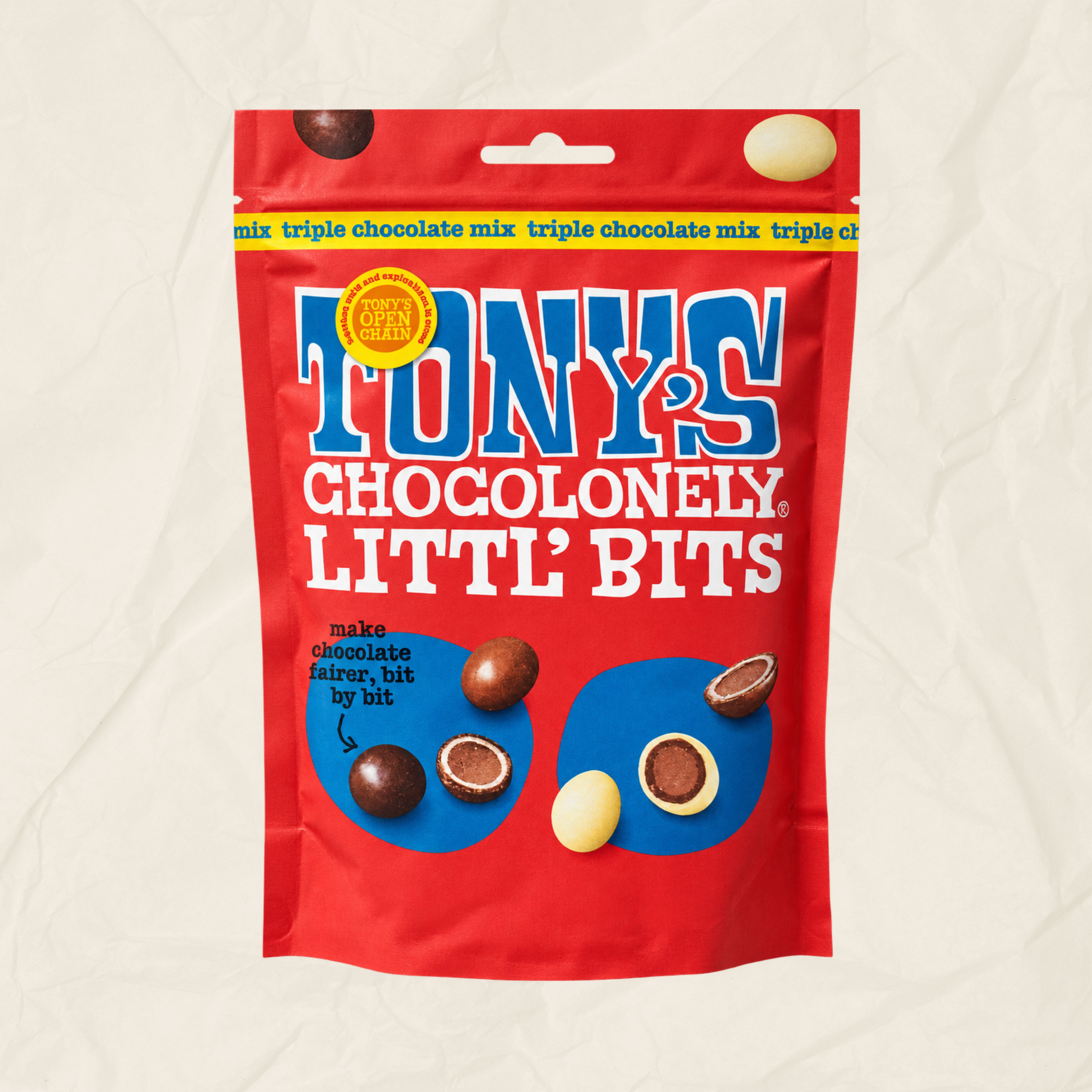 A red bag of Tony's Chocoloney Littl' Bits chocolates, featuring blue and white branding and illustrations of the chocolate pieces, on a textured off-white background.