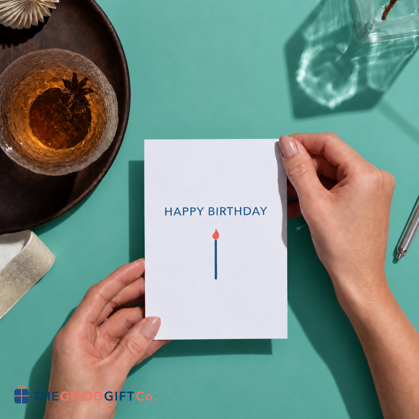 A "Happy Birthday" card being held between 2 hands