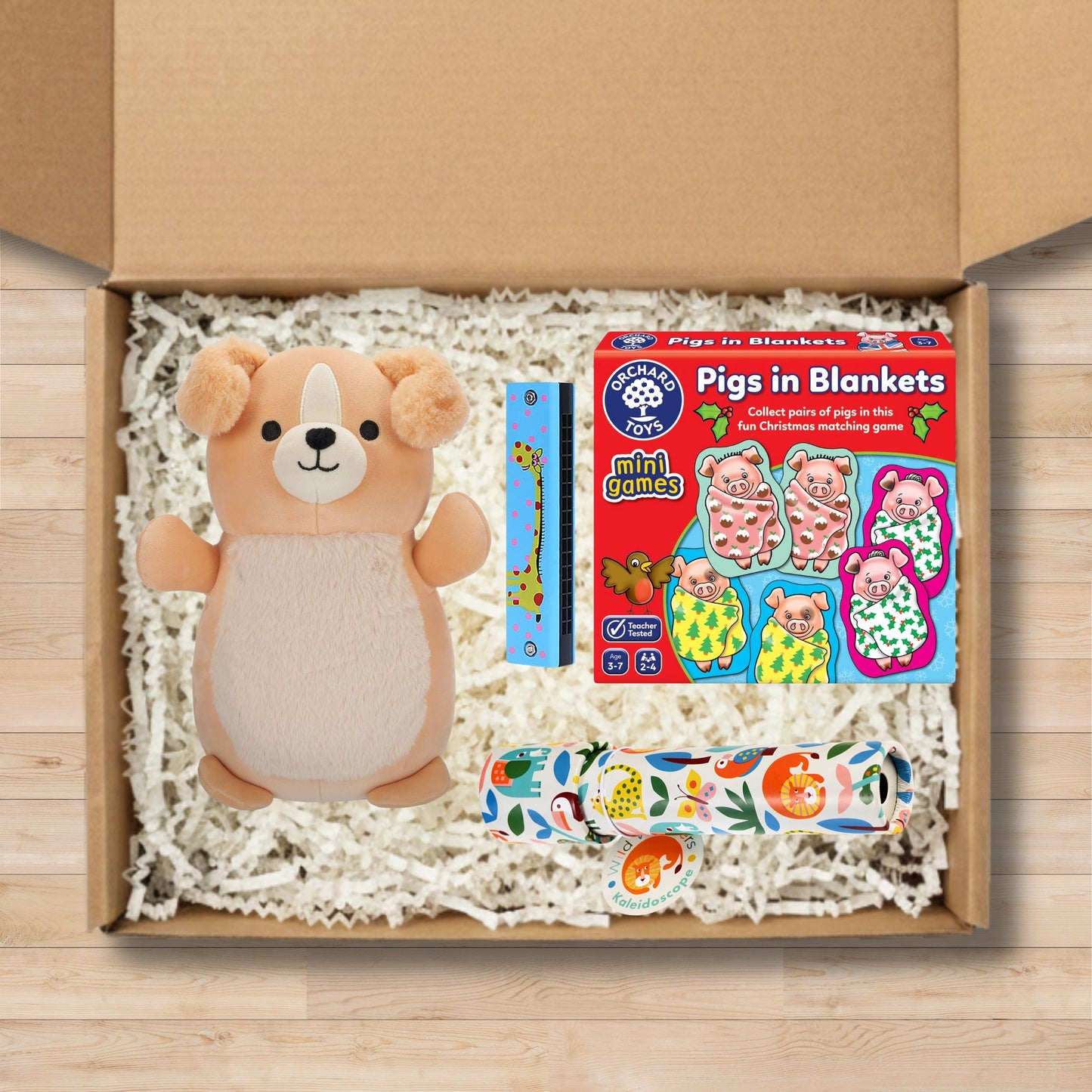 Gift box containing a plush toy, pigs in blankets game box, harmonica, and kaleidoscope