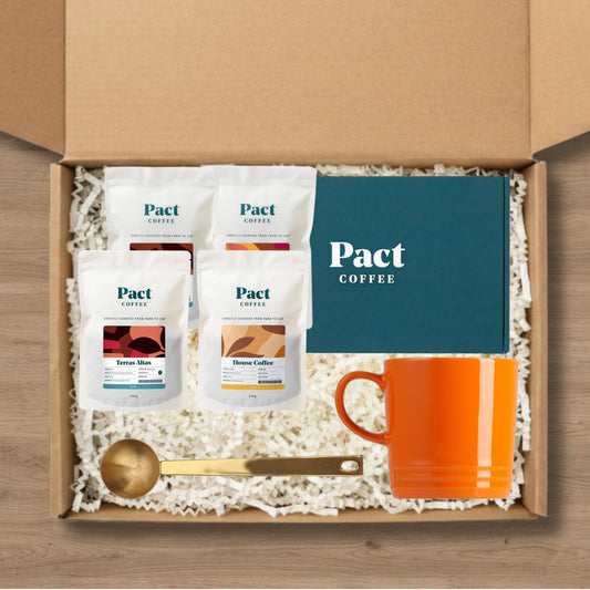 Pact Coffee gift set with coffee bags, a mug, and a coffee scoop