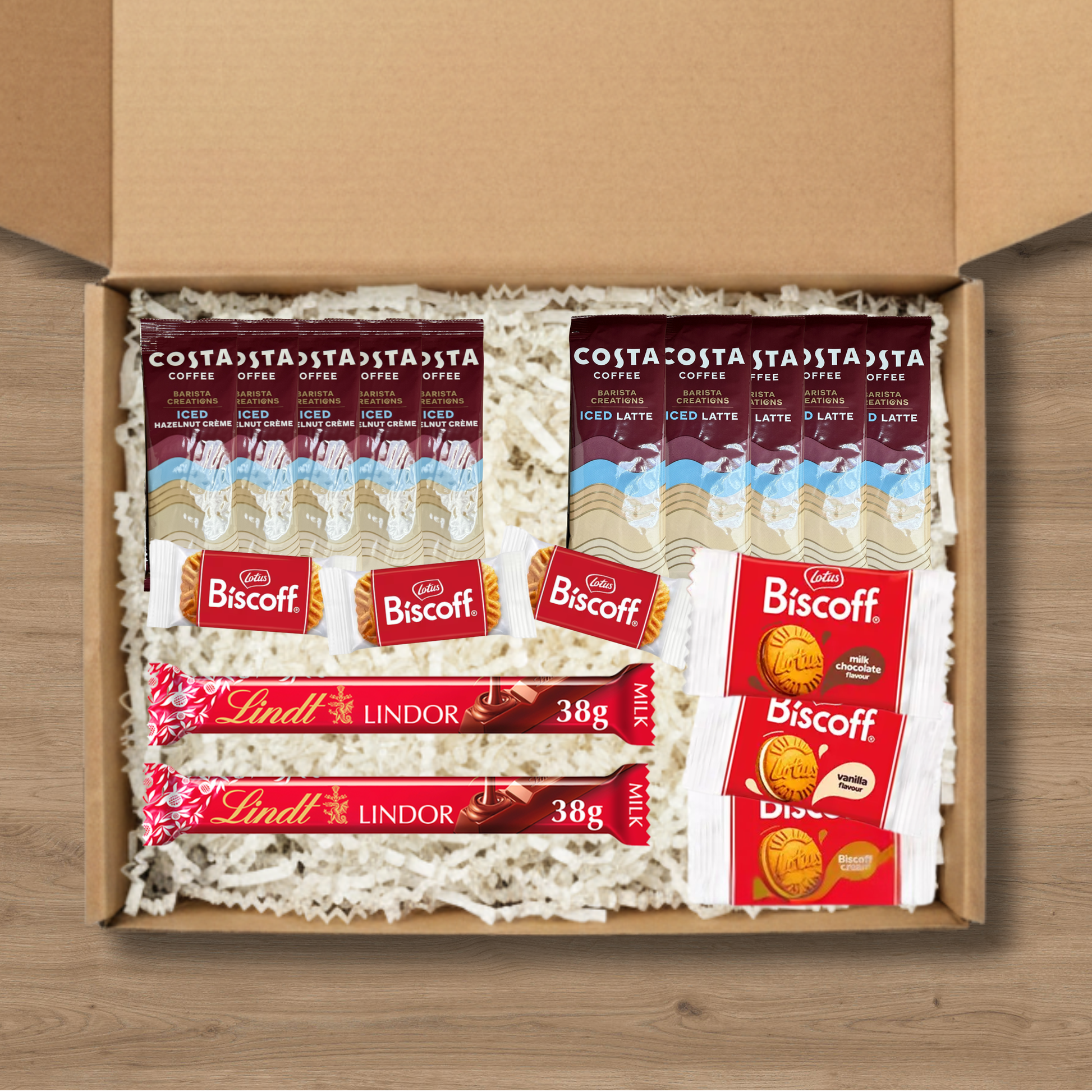 A gift box containing 5 costa coffee iced latte sachets, 5 costa coffee iced hazelnut creme coffee sachets, 3 packs of lotus biscoff biscuits, 1 pack each of lotus biscoff cream, biscoff vanilla cream, and biscoff milk chocolate cream biscuits, and 2 Lindt Lindor chocolate bars