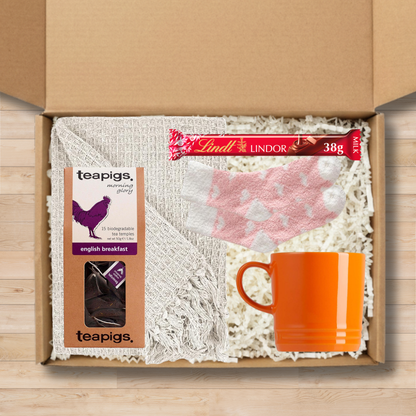 Gift box with a  throw blanket, teapigs tea, Lindt chocolate, a mug, and socks