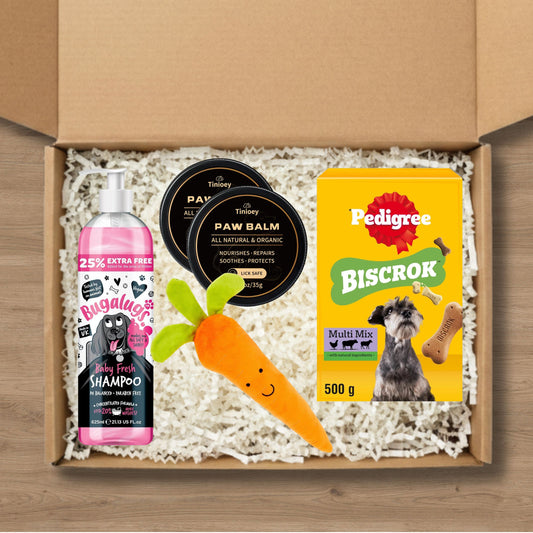 Dog care gift box including shampoo, paw balm, Pedigree Biscrok, and a carrot chew toy.