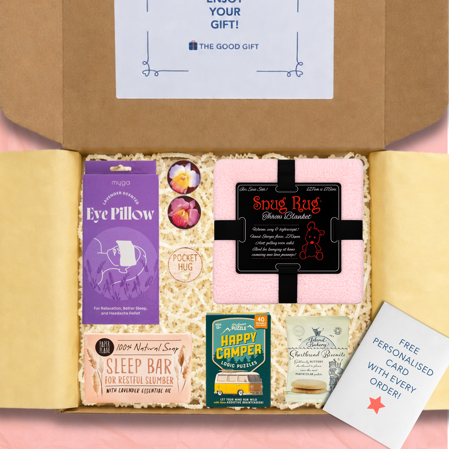 Gift box containing a pink Snug-rug Throw Blanket, a lavender-scented eye pillow, sleep soap bar, a Happy Campers games, tea light candles, shortbread biscuits, and a pocket hug