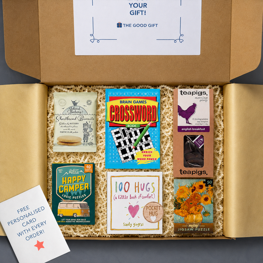 Gift box containing Teapigs english breakfast tea, a 100 Hugs book, shortbread biscuits, a Happy Camper game, a masterworks jigsaw puzzle, a crossword book, and a pocket hug
