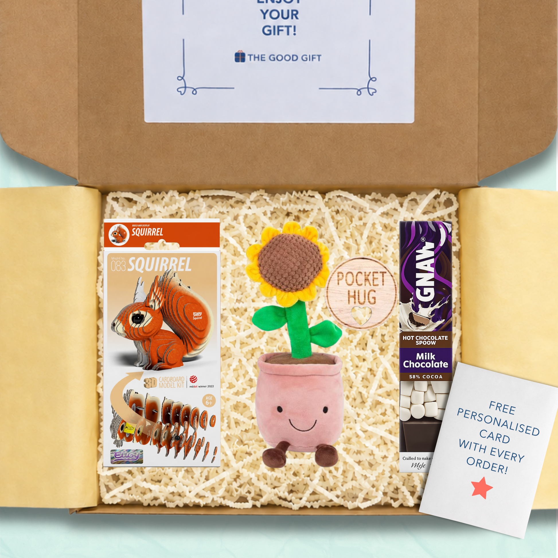 Gift box containing an 3d craftable squirrel, an Animigos sunflower plushie, a GNAW hot chocolate stirrer, and a pocket hug