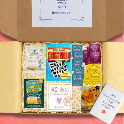 Gift box containing 5 Pukka Lemon, Ginger & Manuka Honey tea,bags, 5 Pukka Night Time Berry tea bags, 5 Pukka Chamomile, Vanilla & Manuka Honey tea bags, a 100 Hugs book, shortbread biscuits, a Happy Camper game, a masterworks jigsaw puzzle, a crossword book, and a pocket hug