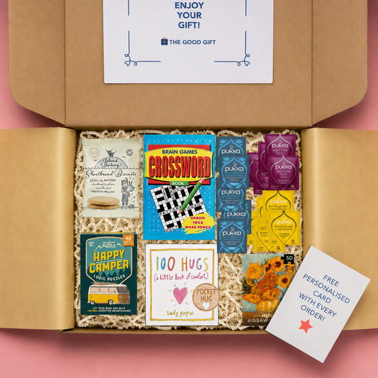Gift box containing 5 Pukka Lemon, Ginger & Manuka Honey tea,bags, 5 Pukka Night Time Berry tea bags, 5 Pukka Chamomile, Vanilla & Manuka Honey tea bags, a 100 Hugs book, shortbread biscuits, a Happy Camper game, a masterworks jigsaw puzzle, a crossword book, and a pocket hug