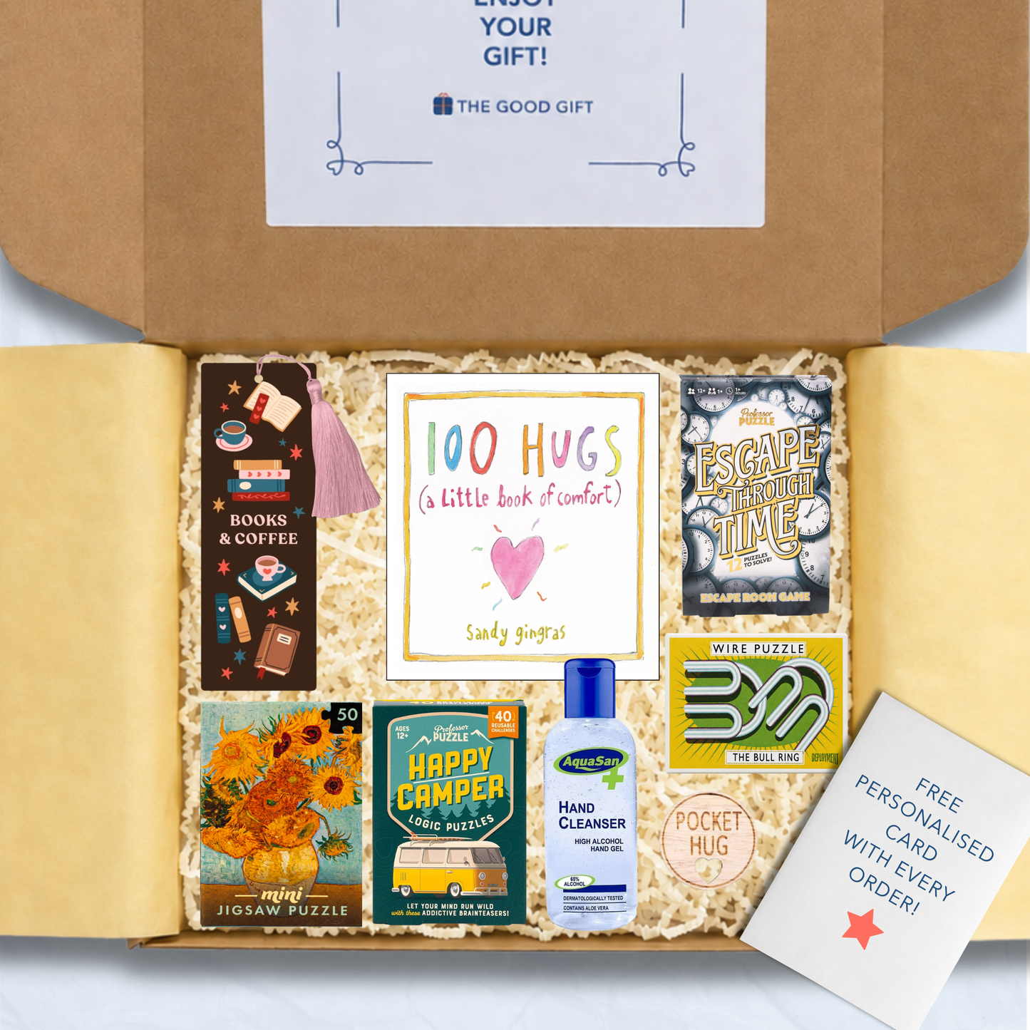 Gift box containing a 100 Hugs book,a bookmark, Happy Campers puzzle game, Escape Through Time escape room game, Masterworks 50 piece jigsaw, a small puzzle, hand sanitiser, and a pocket hug