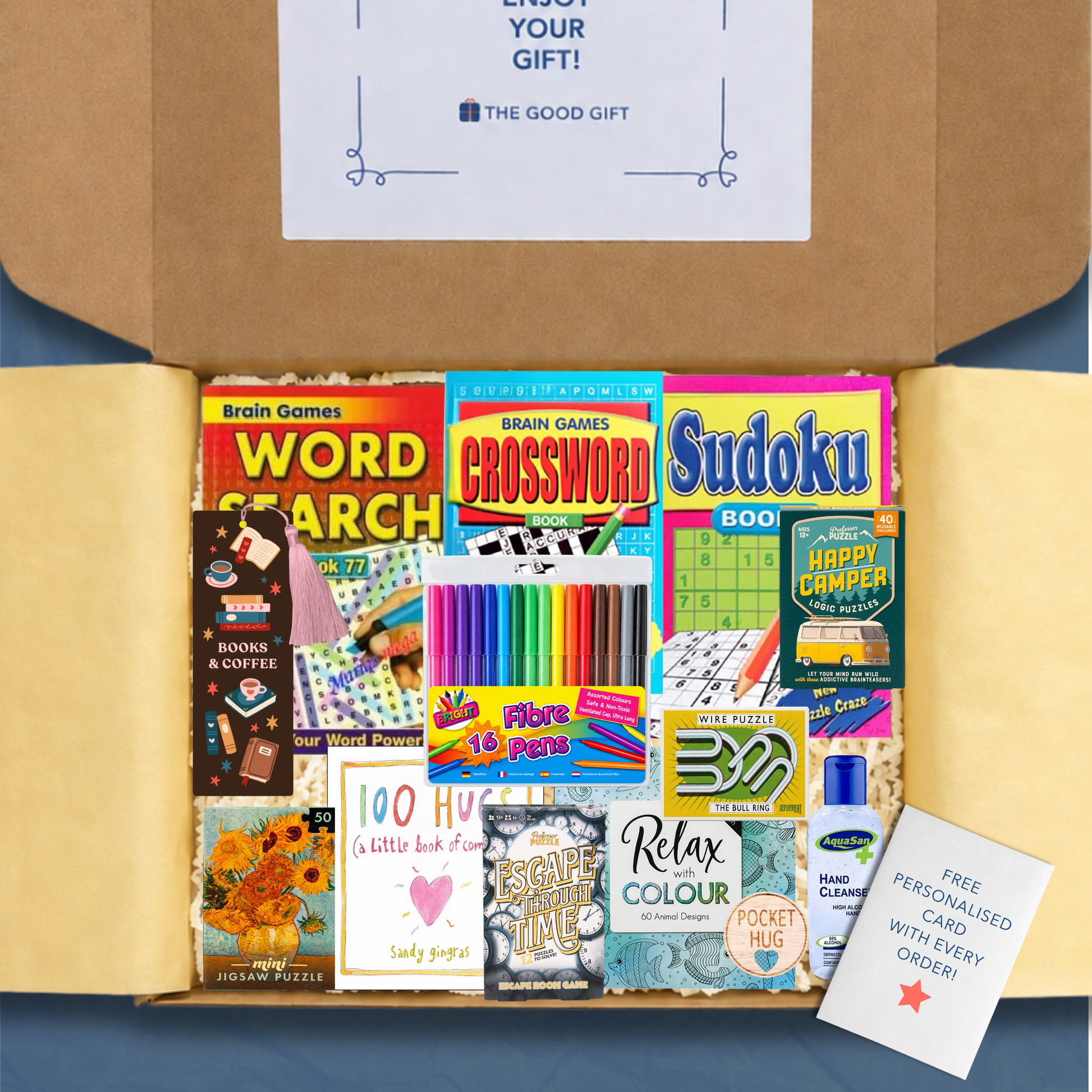 Gift box containing crossword, word search, sudoku and colouring books, a 100 Hugs book, a bookmark colouring felt tip pens, Happy Campers puzzle game, Escape Through Time escape room game, Masterworks 50 piece jigsaw, a small puzzle, hand sanitiser, and a pocket hug