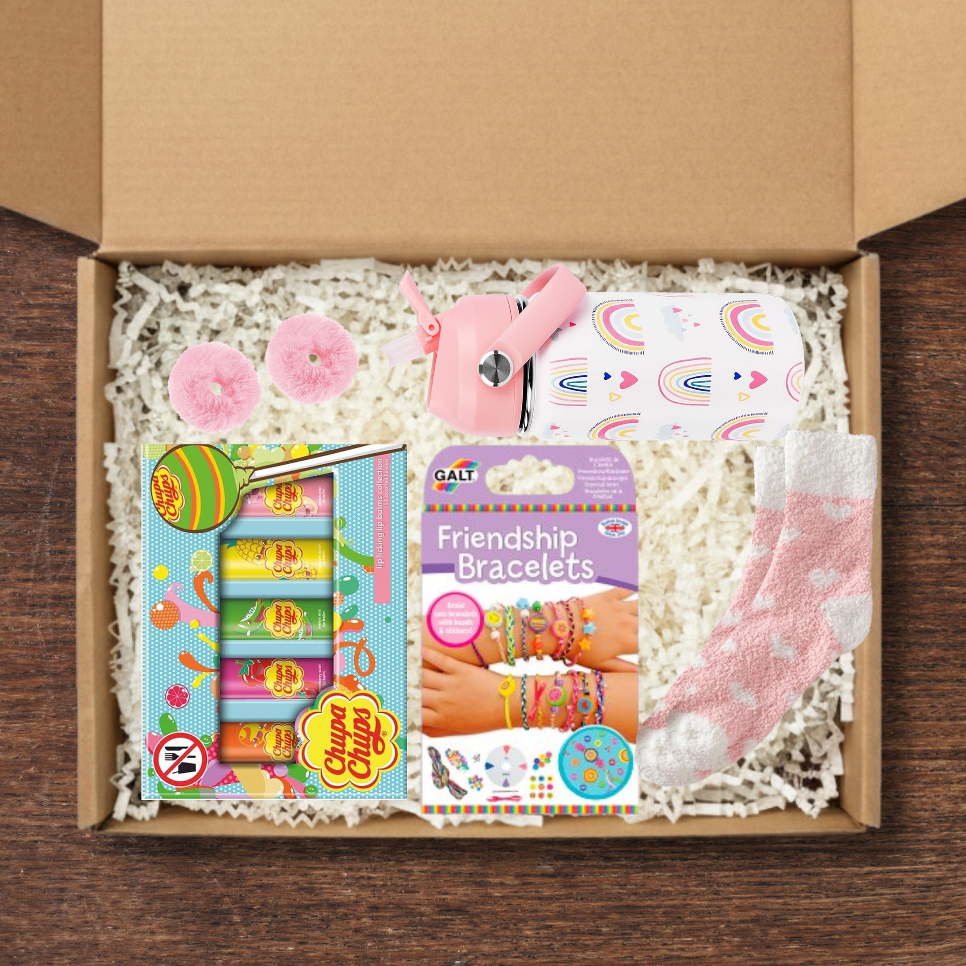 Gift box containing a water bottle, friendship bracelets kit, socks, chupa chups lip balm, socks and hairbands.