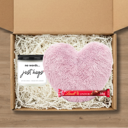Gift box with pink heart-shaped cushion, candle, and Lindt Lindor chocolate bar