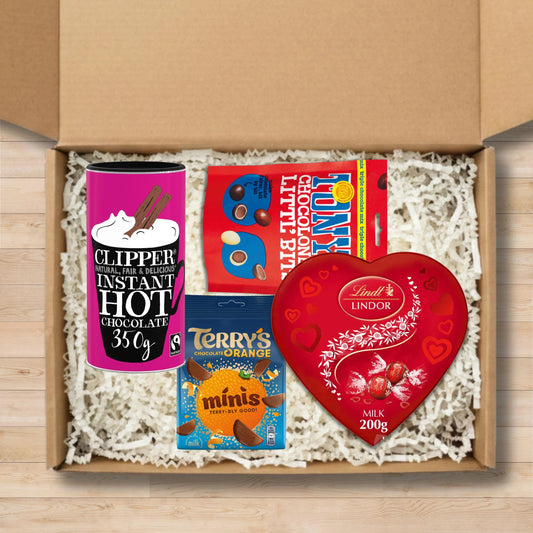 Gift box containing tony's littl bits, terry's chocolate orange minis, lindt lindor chocolate truffles in a heart shaped box, and clipper hot chocolate
