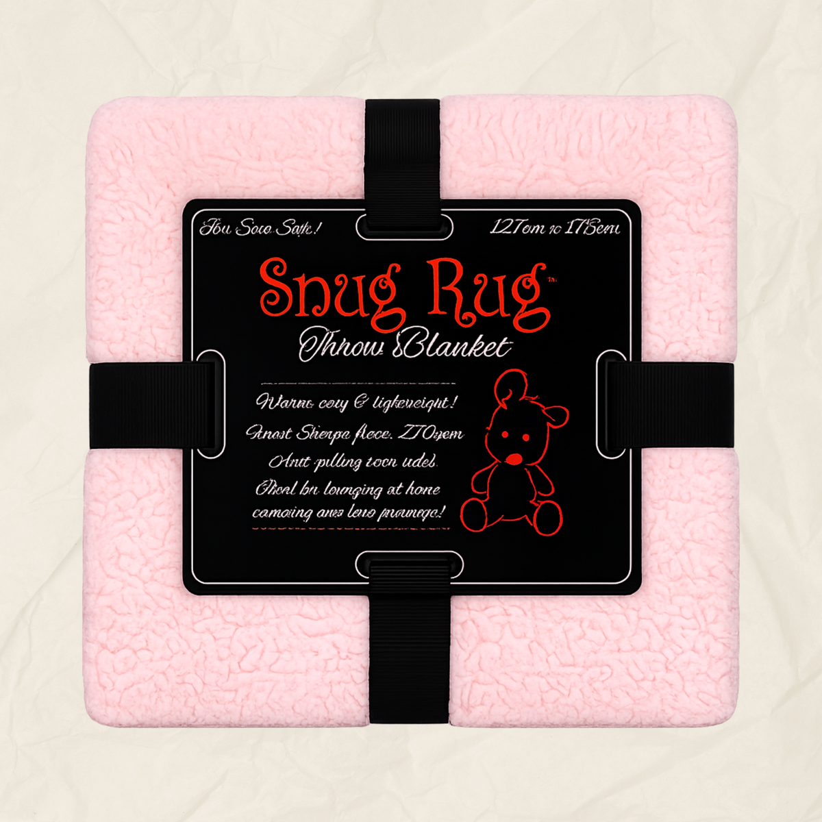 A pink textured throw blanket wrapped with a black strap and a black product label that reads 'Snug Rug Throw Blanket' with size and care text, shown on a light neutral background.