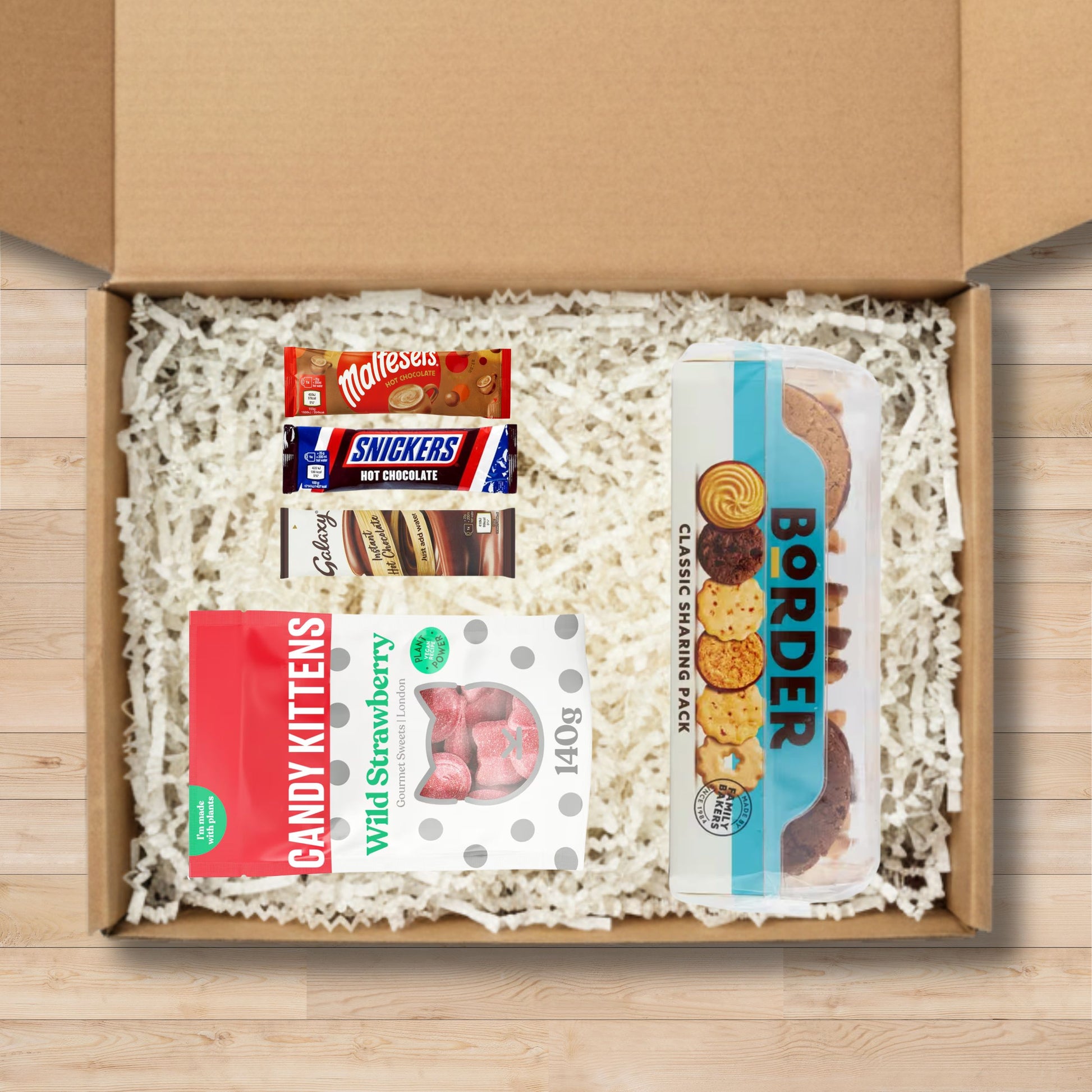 Gift box containing border classic sharing biscuits, candy kittten sweets, and celebrations hot chocoalte sachets.