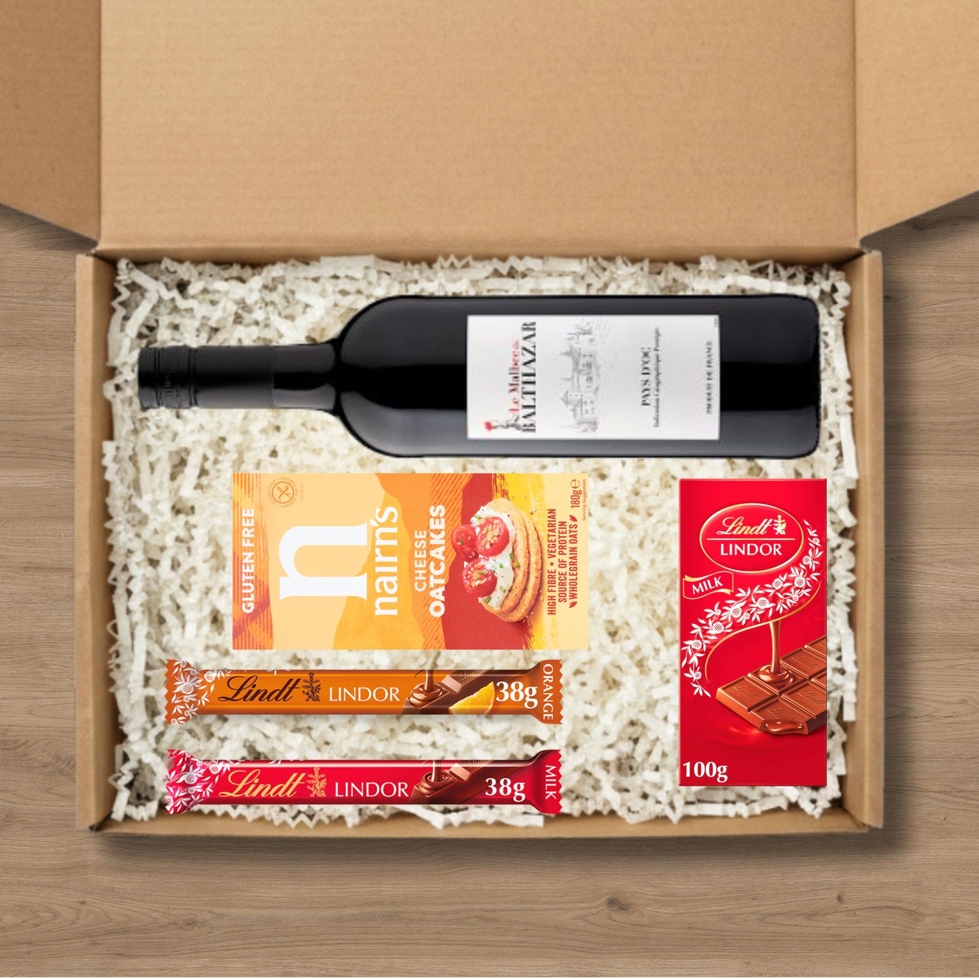 Gift box with a bottle of wine, cookies, and Lindt chocolate bars